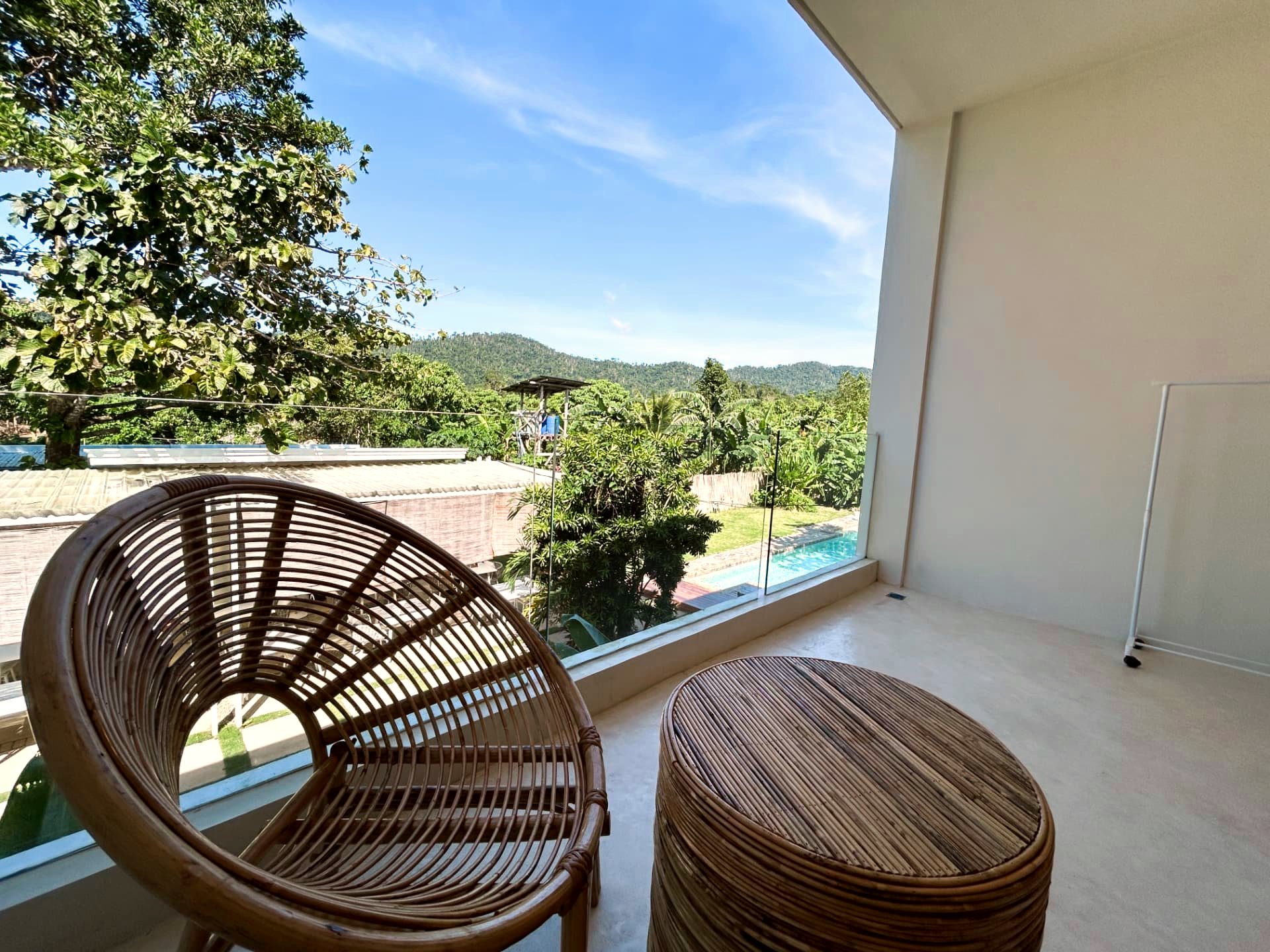 Balcony view over the pool, palms and mountains