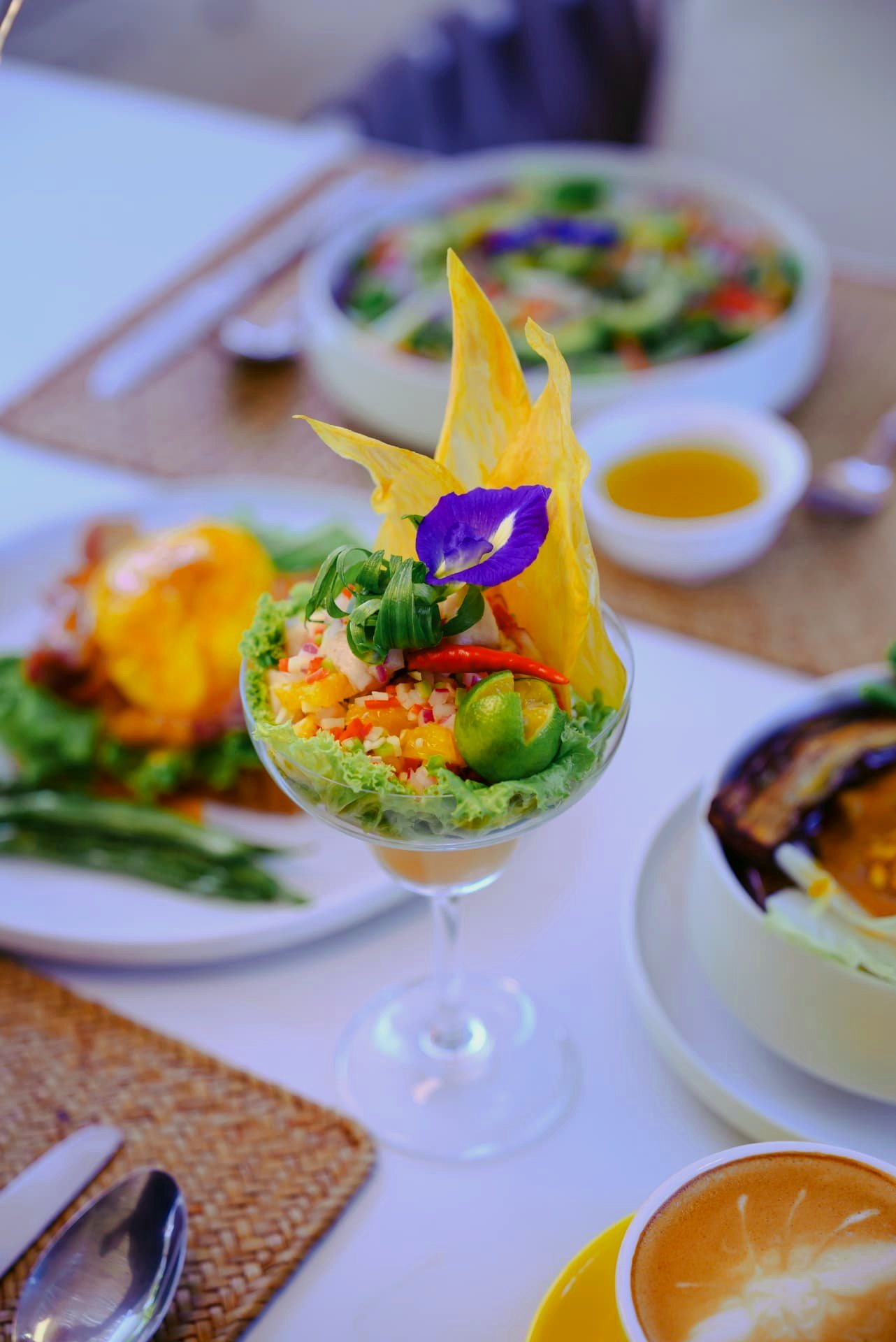 Mango kinilaw served in a glass with edible flowers