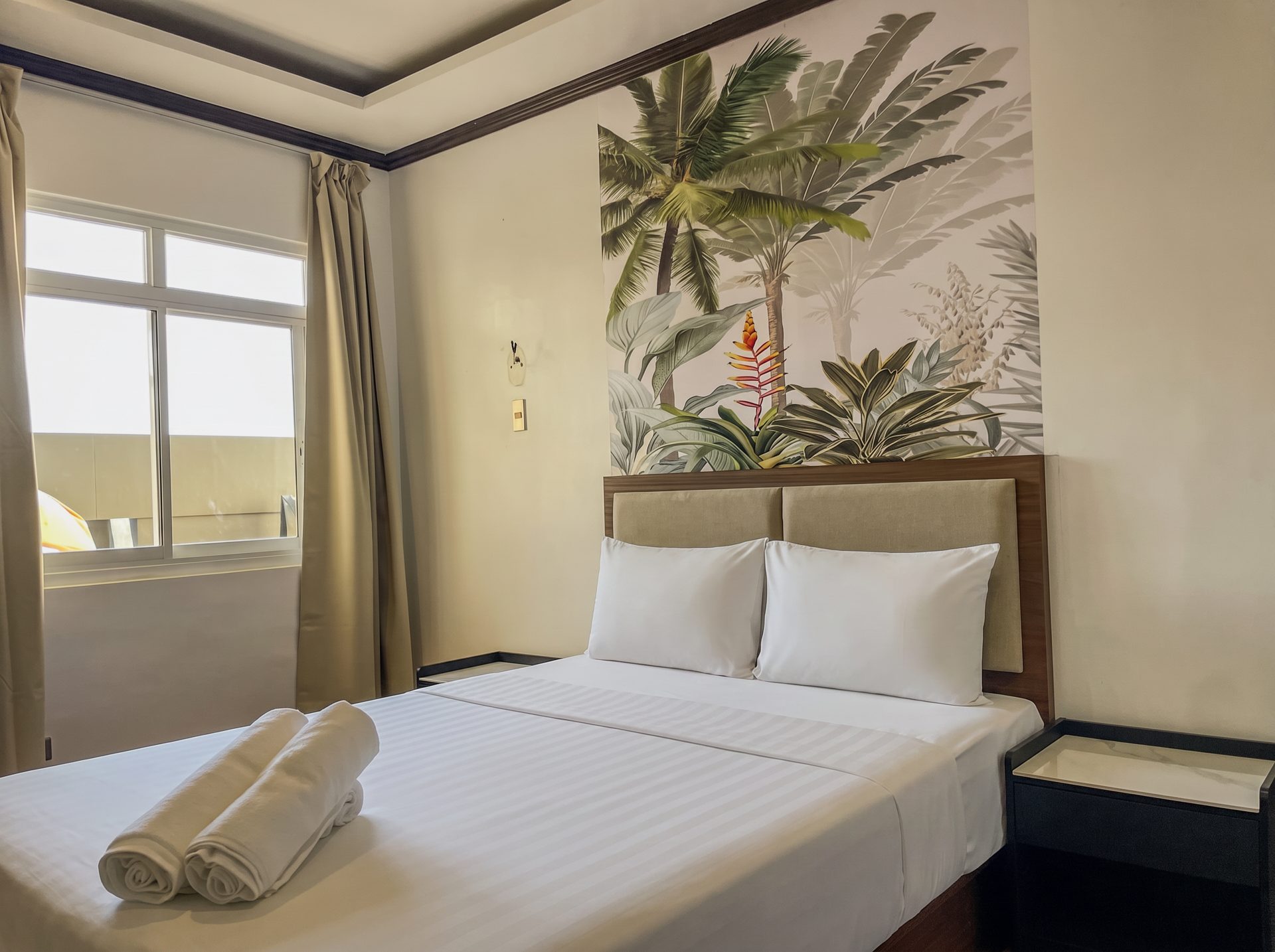 Bright room with tropical mural and window at The Town