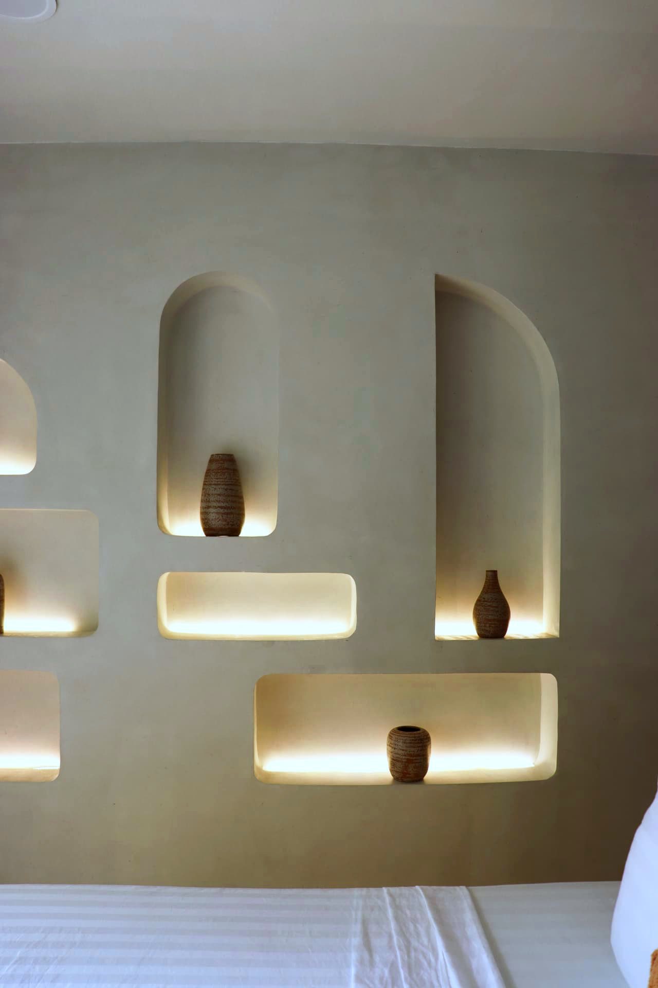 Close-up of sculpted plaster niches with ceramic vases