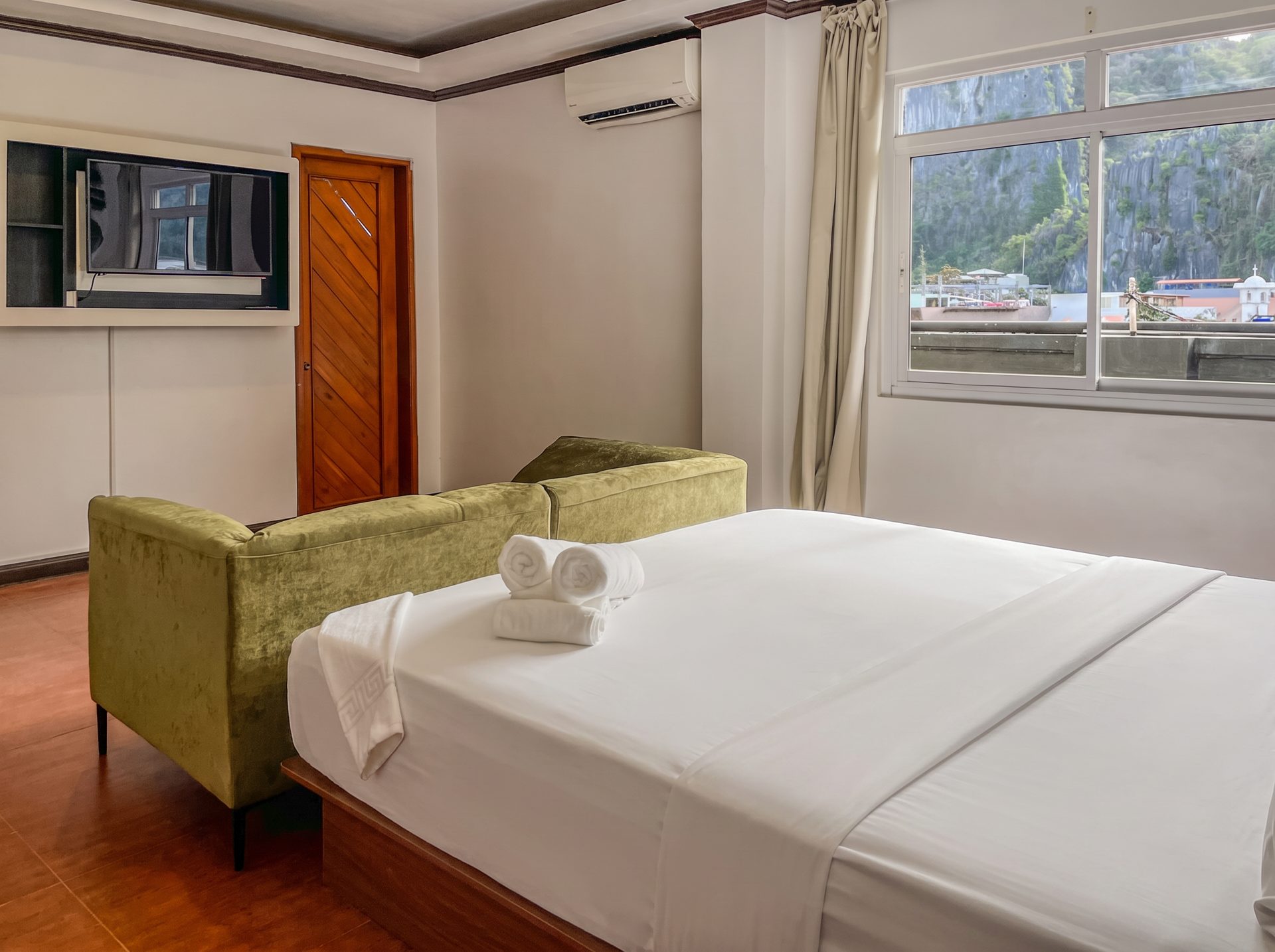 Room with cliff view window and green velvet sofa at The Town