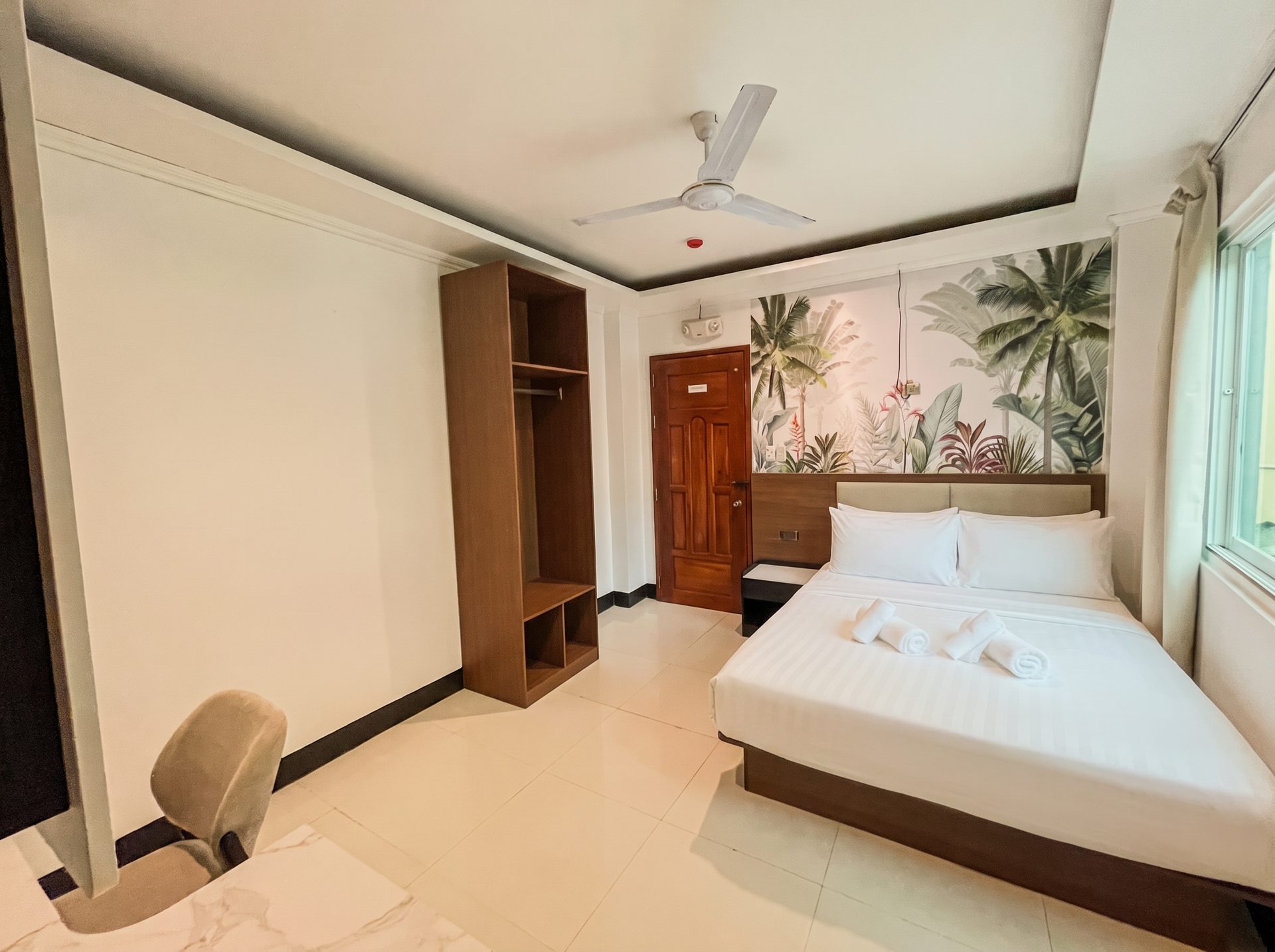 Bright room with wardrobe and tropical mural at The Town