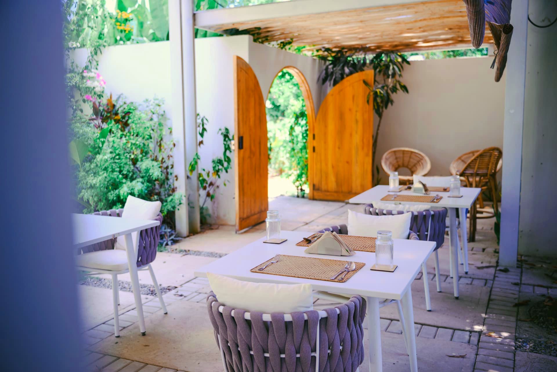 Garden dining tables under a bamboo pergola at Namal Resort