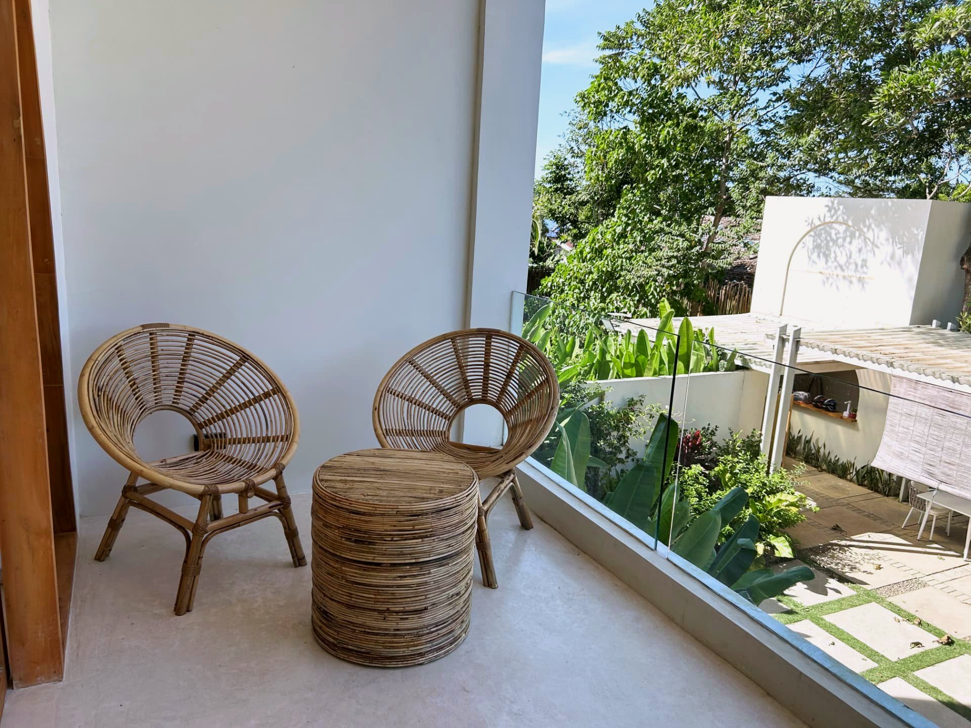 Private balcony with rattan chairs overlooking tropical gardens