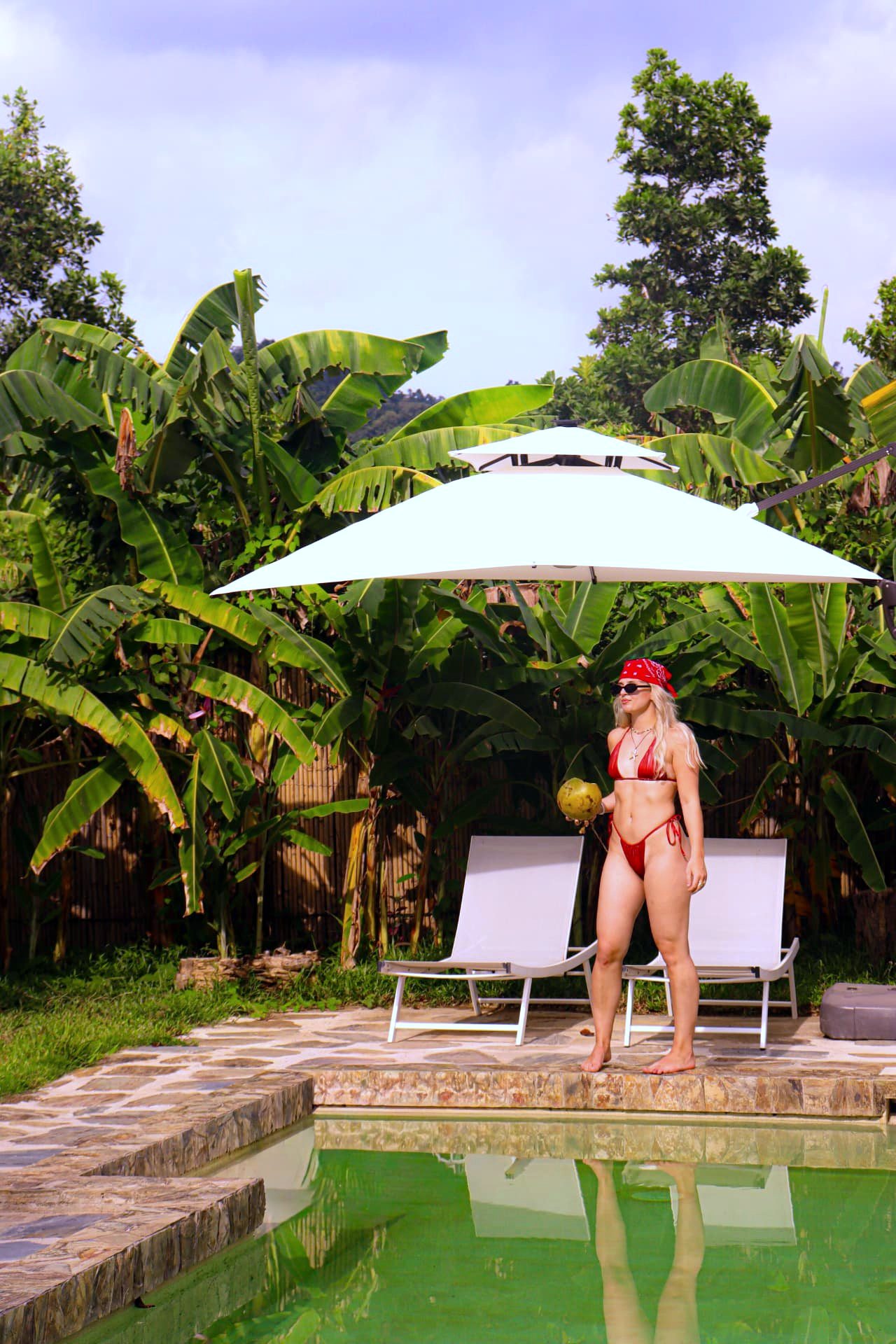 Guest with a fresh coconut by the pool at Namal Resort