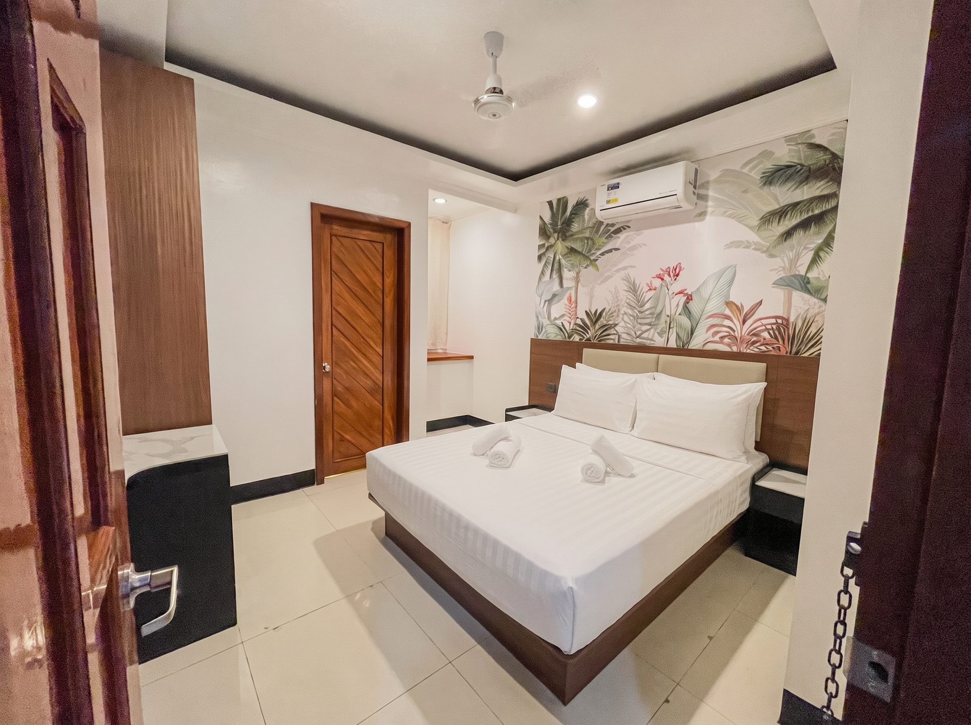 Queen room with tropical mural and marble nightstands at The Town