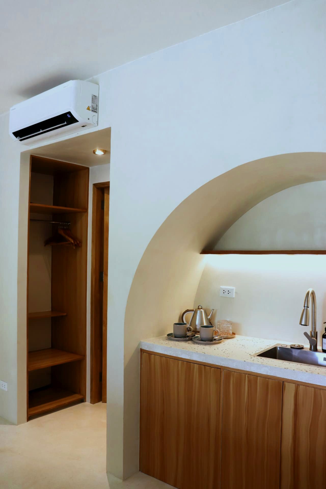 Open wardrobe and arched kitchenette with tea service