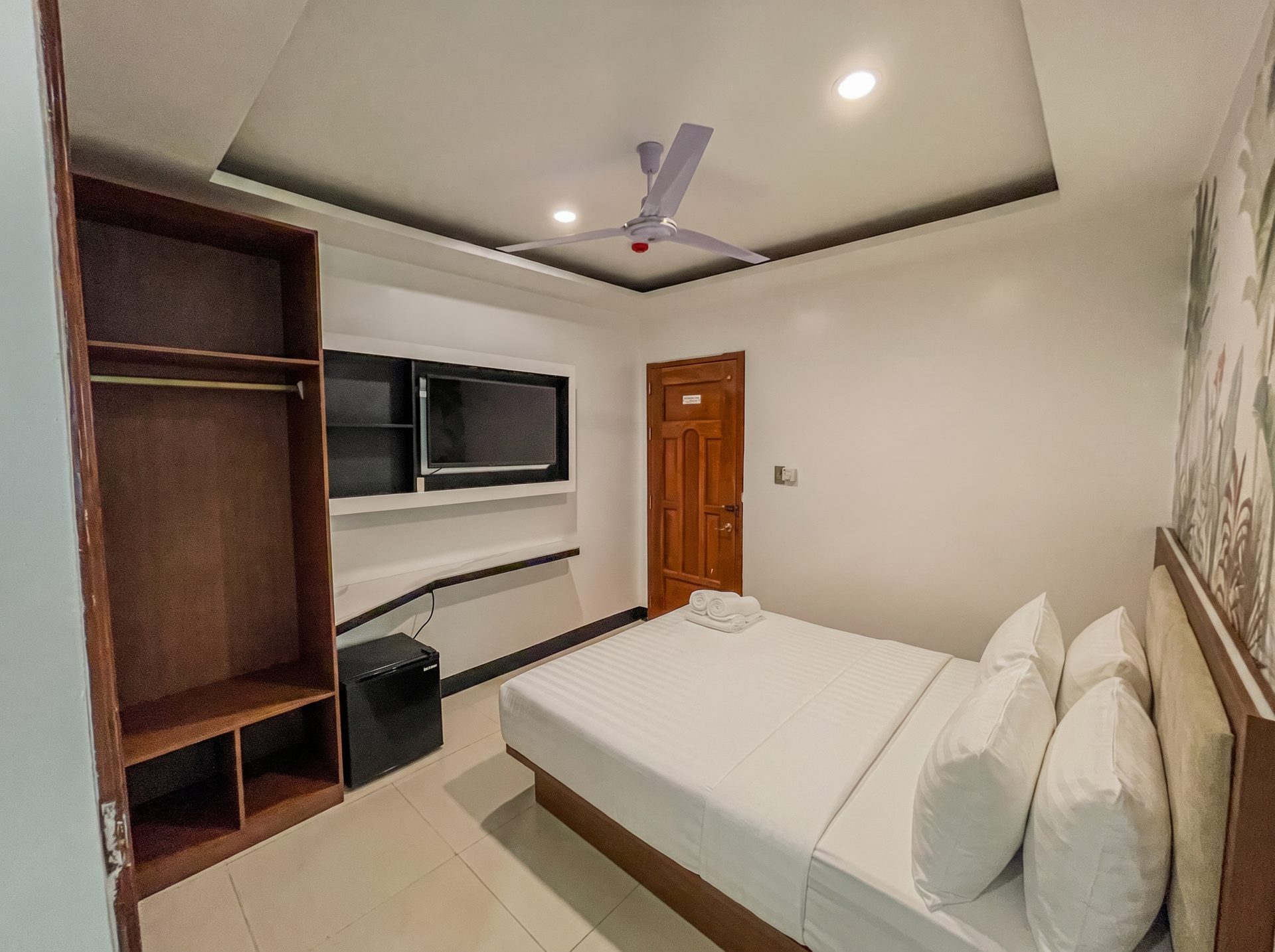 Room with wardrobe, TV and mini fridge at The Town