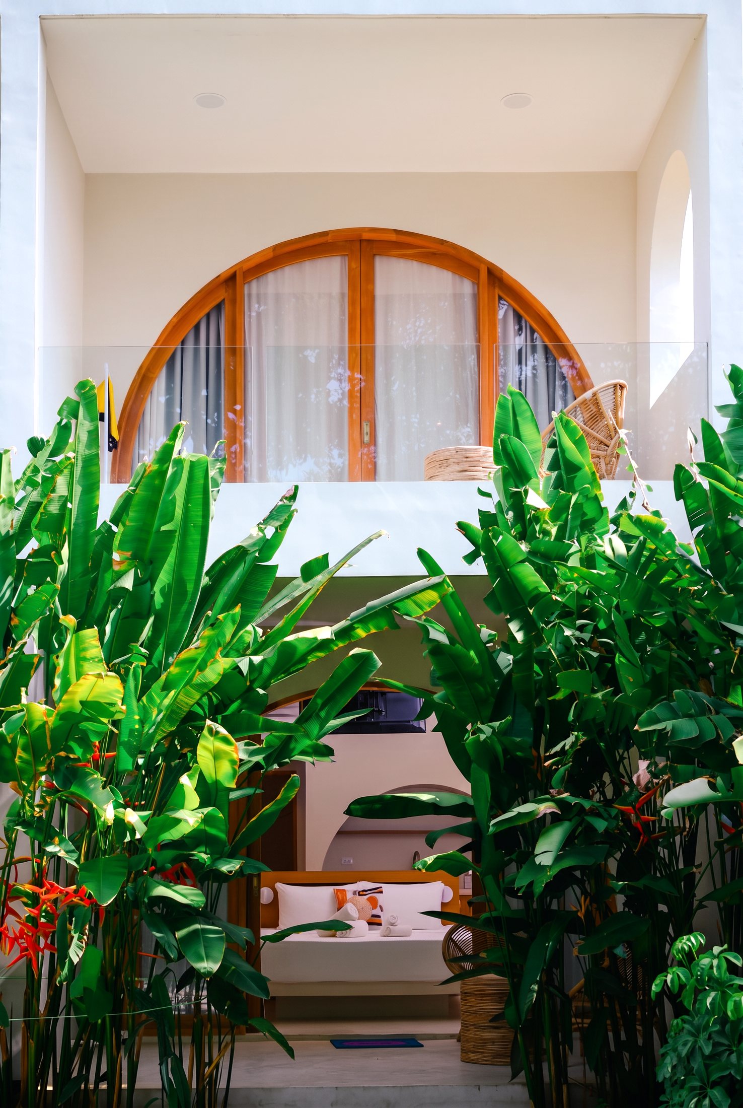 Patio room at Namal Resort with arched wooden doors framed by tropical greenery, El Nido