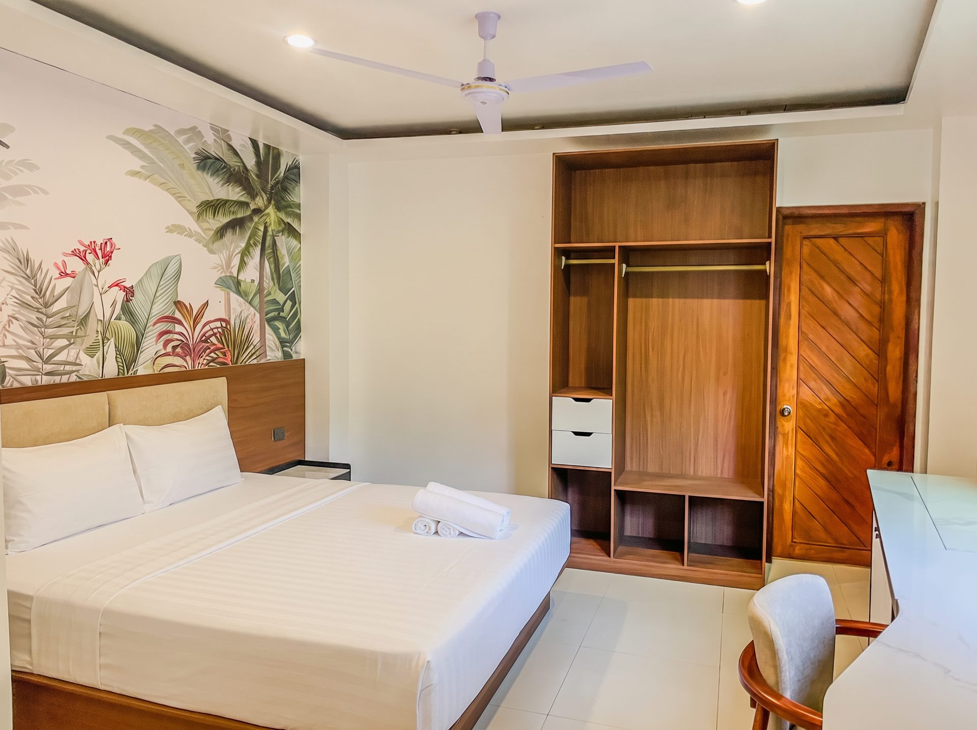 Bedroom with open wardrobe and palm mural at The Town